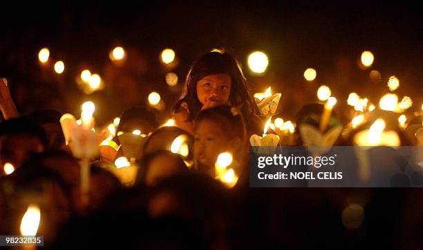 Roman Catholic devotees attend a mass in celebration of Easter Sunday outside St. Domingo Church in Quezon City, suburban of Manila on April 4, 2010....