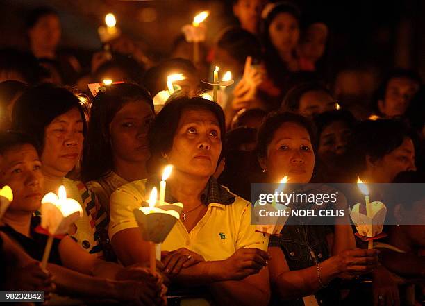 Roman Catholic devotees attend a mass in celebration of Easter Sunday outside St. Domingo Church in Quezon City, suburban of Manila on April 4, 2010....