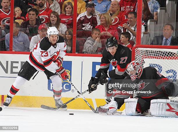 Cam Ward of the Carolina Hurricanes prepares to make a save as teammate Brett Carson and David Clarkson of the New Jersey Devils come around the back...