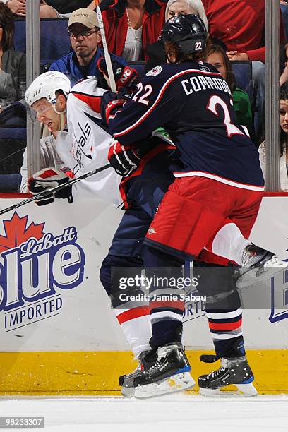 Mike Commodore of the Columbus Blue Jackets finishes a check on Eric Fehr of the Washington Capitals during the second period on April 3, 2010 at...