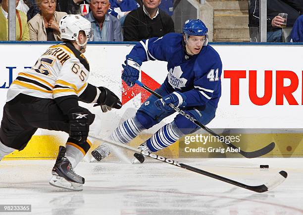 Nikolai Kulemin of the Toronto Maple Leafs looks to pass the puck as Andrew Bodnarchuk of the Boston Bruins defends during game action April 3, 2010...
