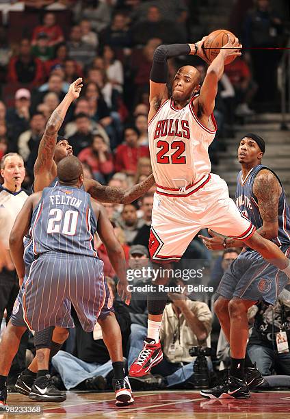 Taj Gibson of the Chicago Bulls gets the rebound before Larry Hughes and Tyrus Thomas of the Charlotte Bobcats can grab the ball during th NBA game...