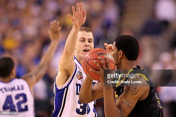 Jon Scheyer of the Duke Blue Devils defends against Devin Ebanks of the West Virginia Mountaineers during the National Semifinal game of the 2010...