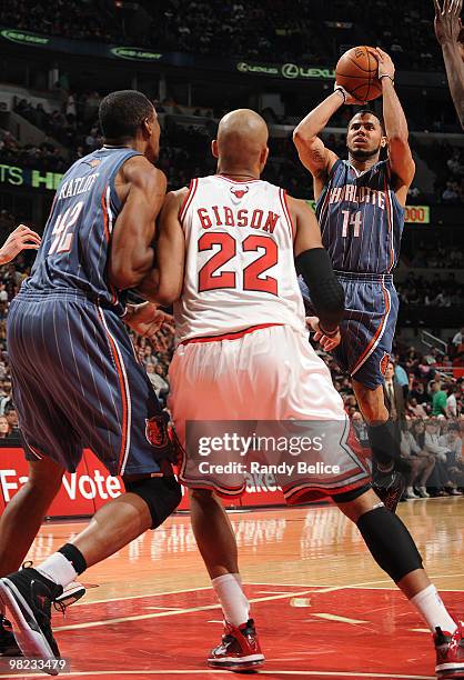 Augustin of the Charlotte Bobcats shoots the jumper over teammate Theo Ratliff and Taj Gibson of the Chicago Bulls during the NBA game against the...