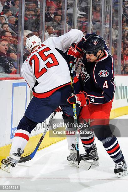 Jason Chimera of the Washington Capitals and Nathan Paetsch of the Columbus Blue Jackets battle for control of a loose puck during the third period...