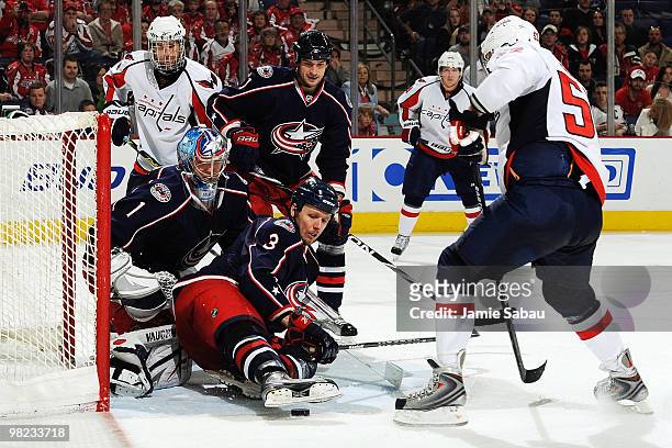 Marc Methot helps goaltender Steve Mason, both of the Columbus Blue Jackets, stops puck before Mike Green of the Washington Capitals is able to get...