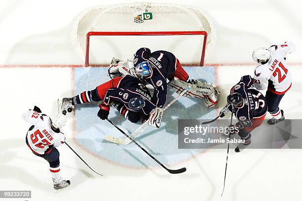 Marc Methot helps goaltender Steve Mason, both of the Columbus Blue Jackets, stops puck before Mike Green of the Washington Capitals is able to get...