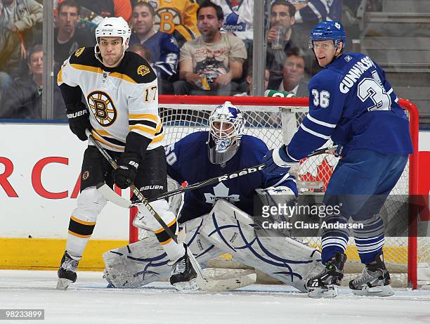 Milan Lucic of the Boston Bruins waits to deflect a shot next to Jonas Gustavsson and Carl Gunnarsson of the Toronto Maple Leafs in a game on April...