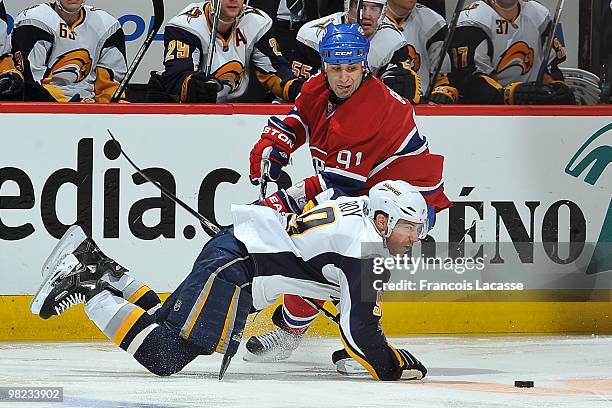 Derek Roy of Buffalo Sabres falls in front of Scott Gomez of Montreal Canadiens during the NHL game on April 3, 2010 at the Bell Center in Montreal,...