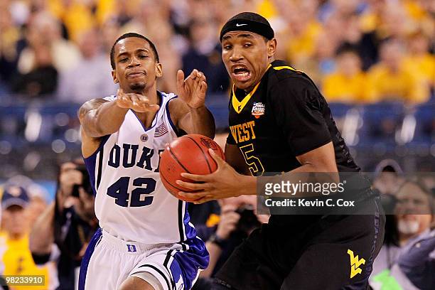 Lance Thomas of the Duke Blue Devils goes for a steal on Kevin Jones of the West Virginia Mountaineers in the second half during the National...