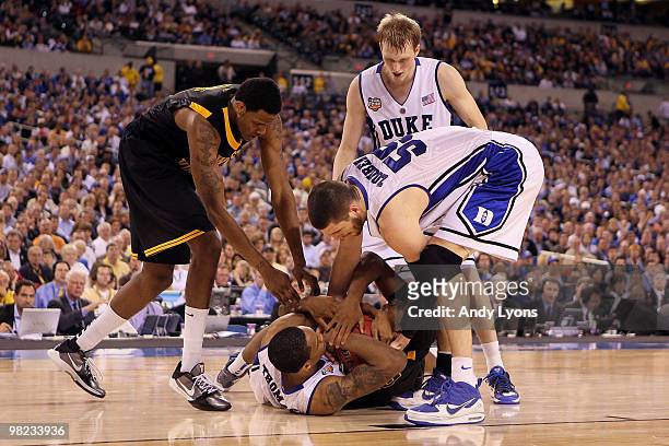 Lance Thomas and Brian Zoubek of the Duke Blue Devils fight for possession of the ball against Kevin Jones and Devin Ebanks of the West Virginia...