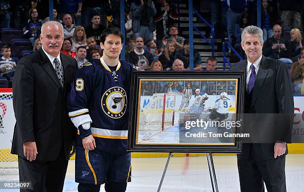 Paul Kariya of the St. Louis Blues poses for a photo with president John Davidson and vice president Larry Pleau before a game against the Dallas...