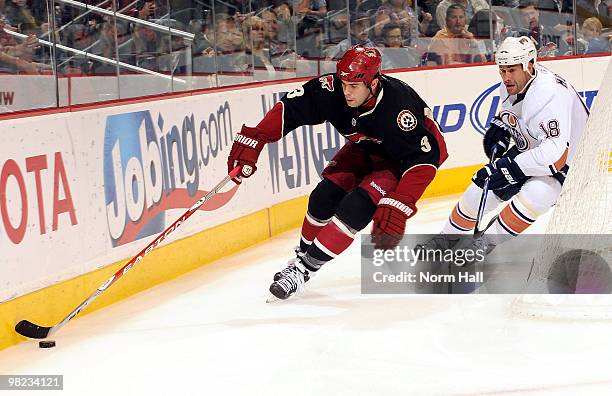 Keith Yandle of the Phoenix Coyotes chases down the puck as Ethan Moreau of the Edmonton Oilers skates in on April 3, 2010 at Jobing.com Arena in...