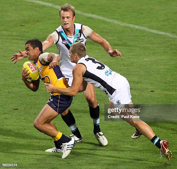 Daniel Kerr of the Eagles attempts to break from a tackle by Steven Salopek and Dean Brogan of the Power during the round two AFL match between the...