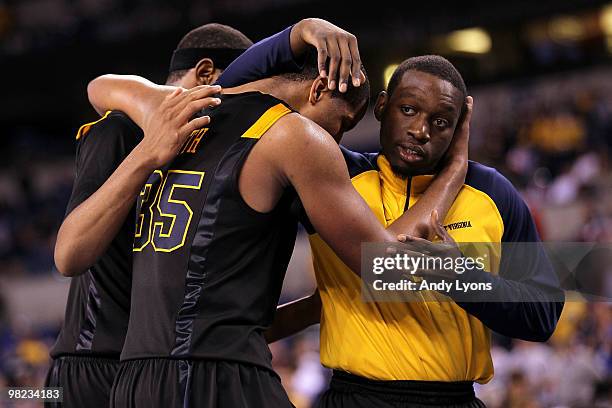 Kevin Jones, Wellington Smith and injured guard Darryl Bryant of the West Virginia Mountaineers console each other after they lost 78-57 against the...