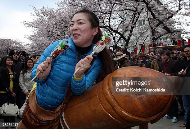 Visitor rides on a wooden phallic figure during the Kanamara Festival, or the Utamaro Festival, near Wakamiya Hachimangu Shrine on April 4, 2010 in...