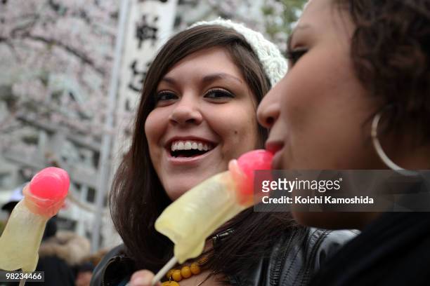 Visitor eat a phallus-shaped candy during the Kanamara Festival, or the Utamaro Festival, near Wakamiya Hachimangu Shrine on April 4, 2010 in...