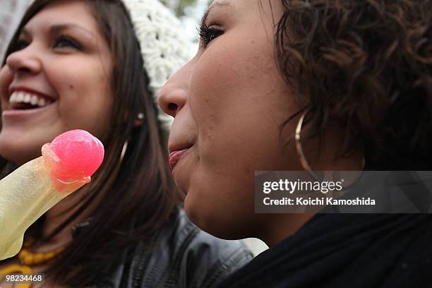 Visitor eat a phallus-shaped candy during the Kanamara Festival, or the Utamaro Festival, near Wakamiya Hachimangu Shrine on April 4, 2010 in...