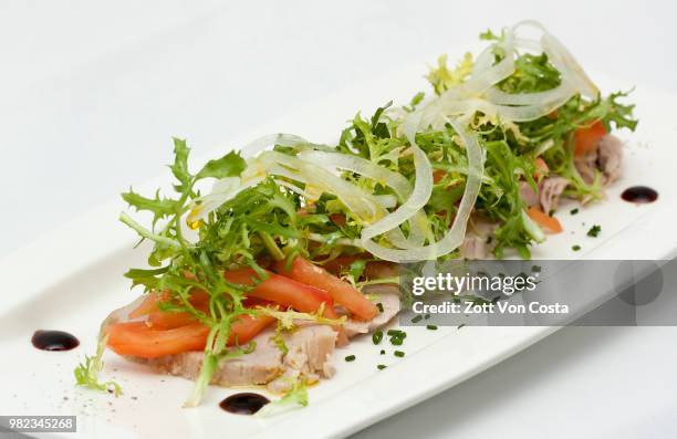 ensalada de solomillo escabechado con tomate cebolla y escarola - cebolla stockfoto's en -beelden