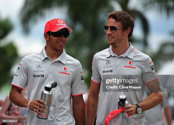 McLaren Mercedes drivers Lewis Hamilton of Great Britain and Jenson Button of Great Britain walk in the paddock before the Malaysian Formula One...
