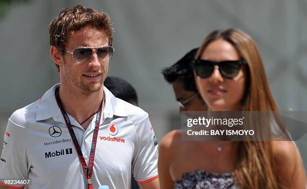 McLaren-Mercedes driver Jenson Button of Britain walks with his girlfriend Jessica Michibata to the paddocks prior to the Formula One's Malaysian...