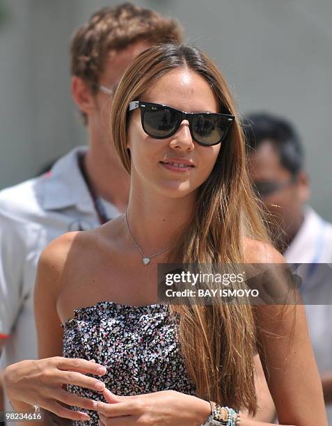 McLaren-Mercedes driver Jenson Button of Britain walks with his girlfriend Jessica Michibata to the paddocks prior to the Formula One's Malaysian...