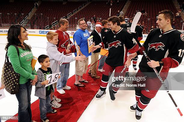 Radim Vrbata and Petr Prucha of the Phoenix Coyotes give their sticks to fans after the shootout win against the Edmonton Oilers on April 3, 2010 at...