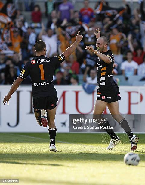 Beau Ryan and Liam Fulton of the Tigers celebrates their final try to defeat the Raiders during the round four NRL match between the Canberra Raiders...