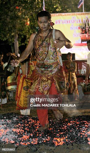 Thai-Chinese devotee walks across hot coals during an annual festival at Chao Mae Kuan-Em temple in Narathiwat province on April 3, 2010. Chao Mae...