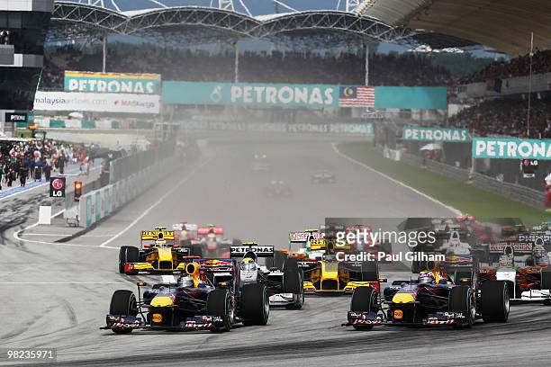 Sebastian Vettel of Germany and Red Bull Racing overtakes team mate Mark Webber of Australia and Red Bull Racing at the first corner at the start of...