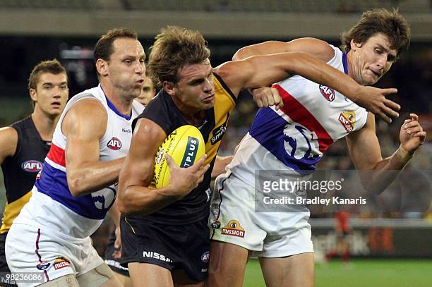Adam Thomson of the Tigers takes on the Bulldogs defence during the round two AFL match between the Richmond Tigers and the Western Bulldogs at...
