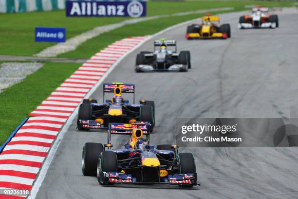 Sebastian Vettel of Germany and Red Bull Racing leads from team mate Mark Webber of Australia and Red Bull Racing during the Malaysian Formula One...