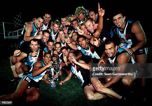 The Port Adelaide team celebrates after winning the Ansett Cup Grand Final between Port Adelaide Power and Brisbane Lions at Football Park in...