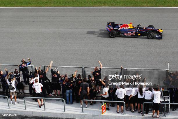 Red Bull Racing team celebrate on the pitwall as Sebastian Vettel of Germany and Red Bull Racing crosses the finishing line to win the Malaysian...