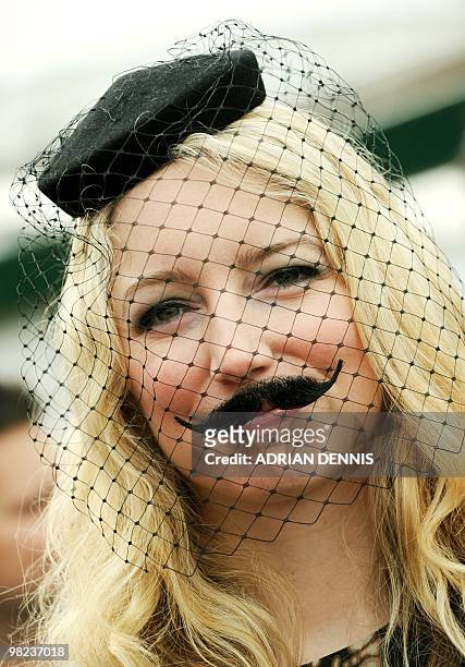 Racegoer arrives wearing an unusual hat with moustache during Ladies Day ahead of the third day of horse racing at the Cheltenham Festival on March...