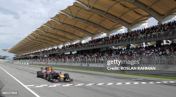 Red Bull-Renault driver Sebastian Vettel of Germany crosses the finish line in Formula One's Malaysian Grand Prix in Sepang on April 4, 2010....