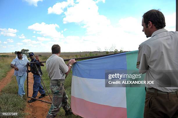 Members of the Afrikaans Resistance Movement put up a AWB flag on the fence of the farm of white supremacist leader Eugene Terre'Blanche in...