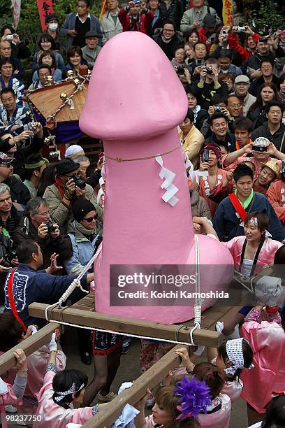 Participants carry a portable shrine with a large pink phallus during the Kanamara Festival, or the Utamaro Festival, near Wakamiya Hachimangu Shrine...