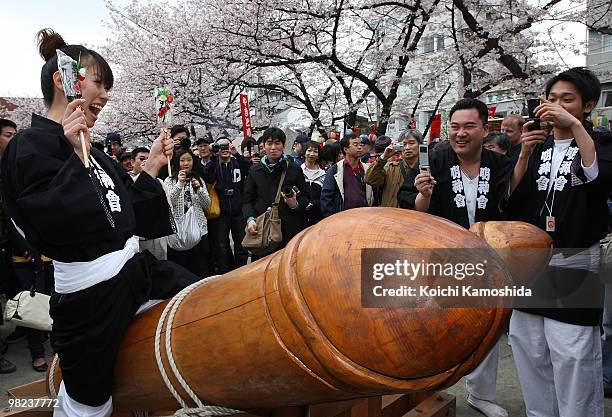 Visitor rides on a wooden phallic figure during the Kanamara Festival, or the Utamaro Festival, near Wakamiya Hachimangu Shrine on April 4, 2010 in...