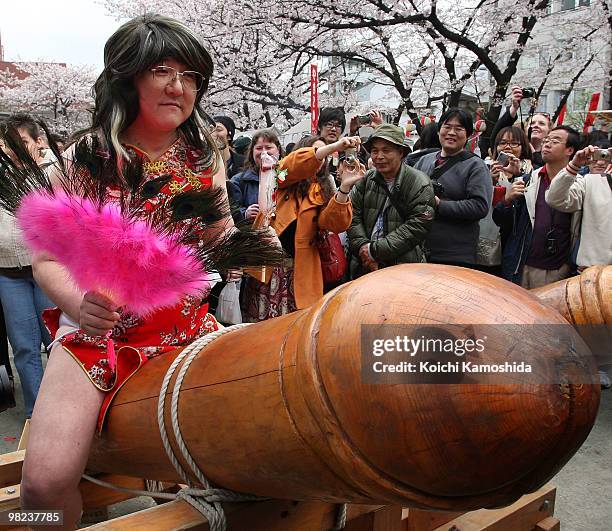 Visitor rides on a wooden phallic figure during the Kanamara Festival, or the Utamaro Festival, near Wakamiya Hachimangu Shrine on April 4, 2010 in...