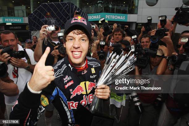 Sebastian Vettel of Germany and Red Bull Racing celebrates with his team mates in the paddock after winning the Malaysian Formula One Grand Prix at...