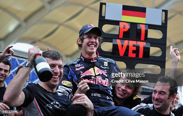 Sebastian Vettel of Germany and Red Bull Racing celebrates with his team mates after winning the Malaysian Formula One Grand Prix at the Sepang...