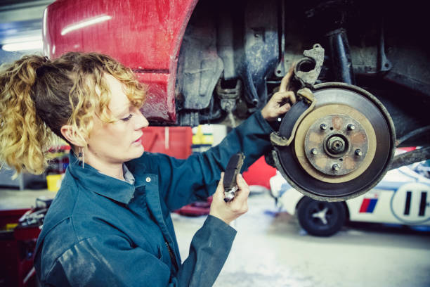 female mechanic inspecting the brake pad