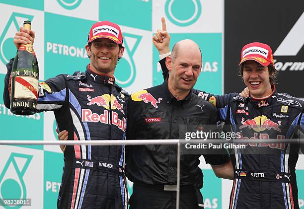 Race winner Sebastian Vettel of Germany and Red Bull Racing celebrates on the podium with second placed team mate Mark Webber of Australia and Red...