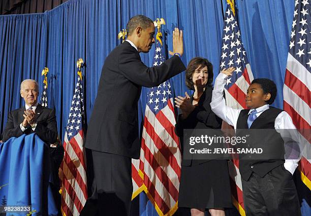 President Barack Obama gives a "high five" to 11 year-old Marcelas Owens after holding a rally celebrating the passage and signing into law of the...