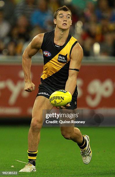 Dustin Martin of the Tigers handballs during the round two AFL match between the Richmond Tigers and the Western Bulldogs at the Melbourne Cricket...