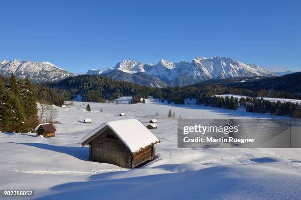 frozen lake geroldsee (lake wagenbrüchsee) with hay shed and karwendel mountains in background, winter. - krün ストックフォトと画像