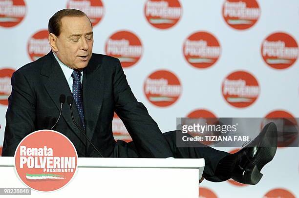 Italian Prime Minister Silvio Berlusconi lifts his leg during a support rally for the unseen Party of Freedom candidate and Lazio region presidential...