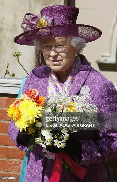 Britain's Queen Elizabeth II holds flowers as she leaves an Easter Sunday church service in Windsor on April 4, 2019. AFP PHOTO / ALASTAIR GRANT /...