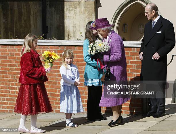 Britain's Queen Elizabeth II receives flowers from children as she leaves an Easter Sunday church service in Windsor on April 4, 2019. AFP PHOTO /...